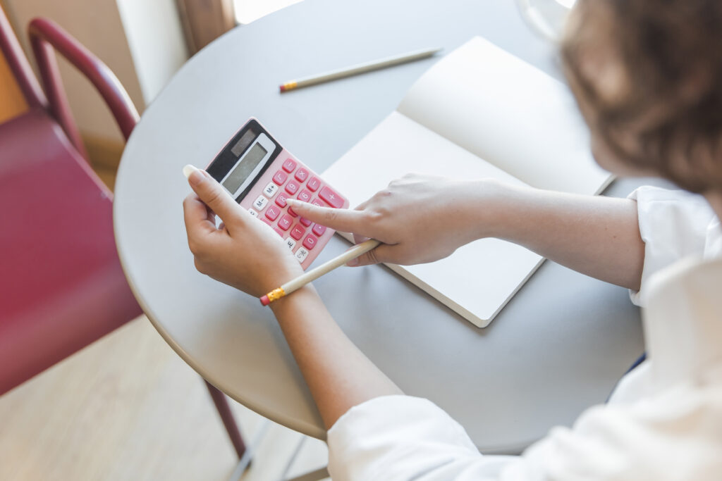 crop-teen-using-calculator-table